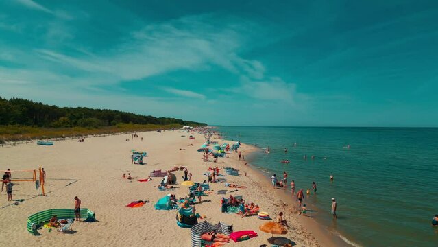 beach with forest and blue water, tourists on vacation, Jastarnia, Hel peninsula