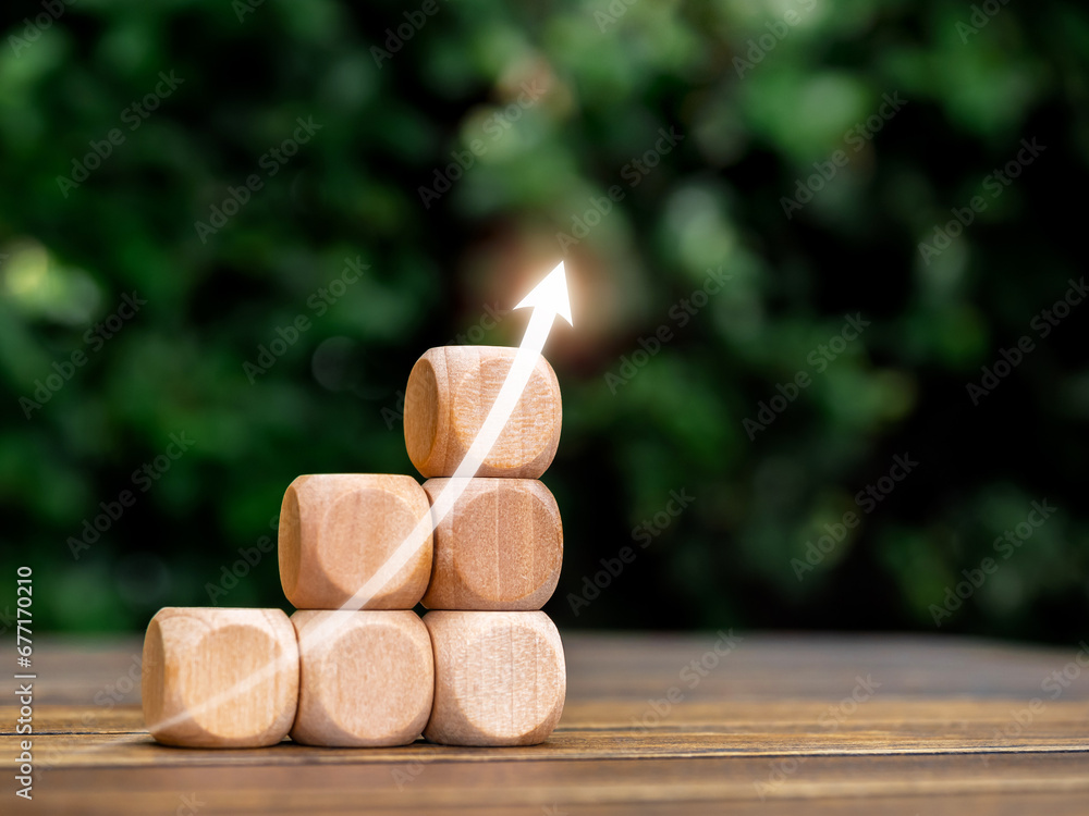 Poster rising up glowing arrow on empty wooden cube blocks as a business graph or chart steps on table and 