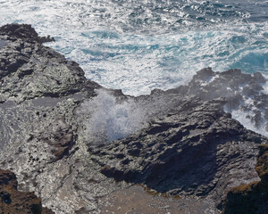 Close-up photo of a wave breaking on a rock on a beautiful Makapuu Beach Park, Island of Oahu, Hawaii