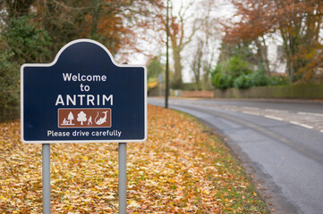Sign saying Welcome To Antrim, Please Drive Carefully, with autumn leaves