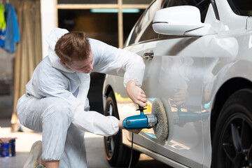 Hands with orbital polisher. Car polishing waxing. Auto mechanic car man worker working painting in...