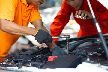 male mechanic repairs car in garage. Car maintenance and auto service garage concept. Close up...