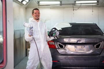 Male worker very happy and excited doing winner gesture. paint garage. paint room at garage. Auto mechanic car hispanic man worker working painting in car paint chamber. Body paint garage