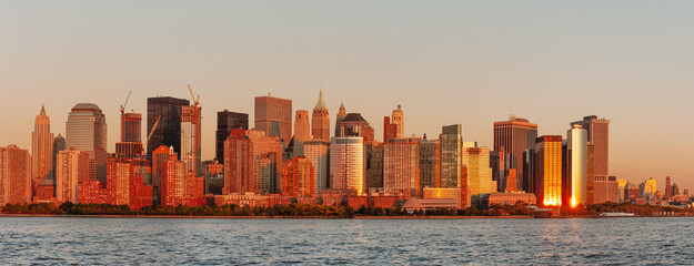 Panoramic view of Lower Manhattan West side and Financial District across Hudson river at sunset,...