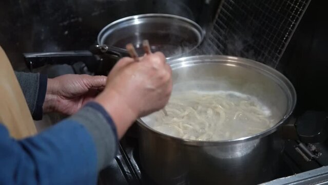 蕎麦を茹でる女性