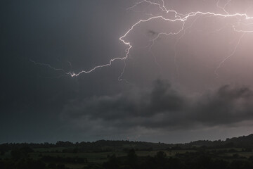 Lightning bolt on the dark cloudy sky