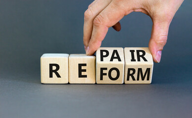 Reform and repair symbol. Concept words Reform Repair on wooden block. Beautiful grey table grey...