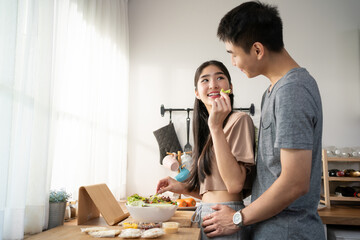 Love, romance and fun Asian couple hugging, cooking in a kitchen and sharing an intimate moment....