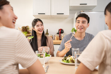 Happy Asian friends lunching with healthy food home- Young people having fun eating meal and...