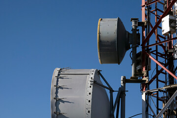 Telecommunication antenna with multiple satellite against the blue sky