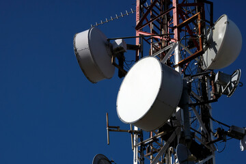 Telecommunication antenna with multiple satellite against the blue sky