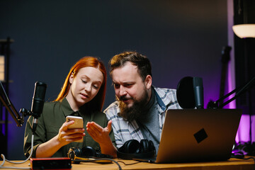 Online show hosts in a home studio. Online bloggers, with a phone in their hands, read the comments...