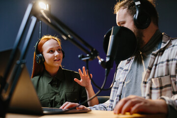 Man having conversation with woman in internet broadcast using professional microphone and audio...