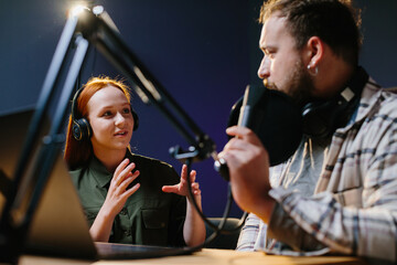 Man having conversation with woman in internet broadcast using professional microphone and audio mixer. Online radio station host recording podcast interviewing guest in late night talk show.