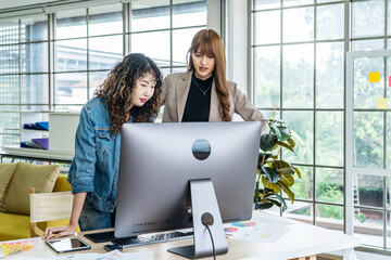 Collaboration of graphic design business people with computer in an office company, Two corporate women in creative marketing team working on project management