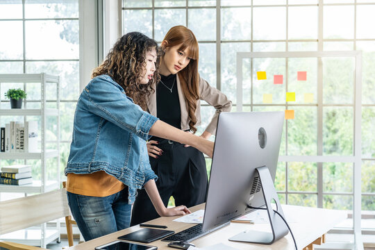 Collaboration of graphic design business people with computer in an office company, Two corporate women in creative marketing team working on project management