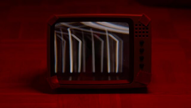 retro flickering tube tv monitor isolated under red light in dark room, cool video or photo placeholder for your content in 4k. damaged tv signal.