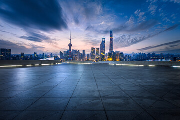 Square floor and city buildings skyline in Shanghai at sunset
