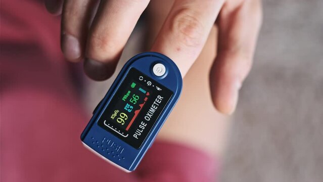 Man measures pulse and oxygen saturation with a pulse oximeter at home. Modern device measuring heart rate pulse monitoring heartbeat health. Monitoring oxygen level in blood. Care, Medical technology