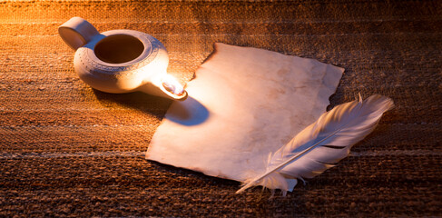 Old paper and feather lit by a lamp