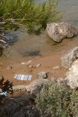 Spiaggia sul mare con rocce molto grandi ed asciugamano isolato