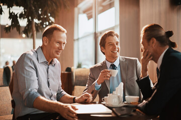 Happy businessmen sitting in cafe talking after work