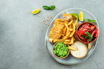 Crispy Fish and Chips served with mashed peas, vegetable salad, tartar sauce, Traditional British food, place for text, top view