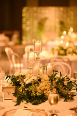 Wedding table decorations with candles in a light bokeh background