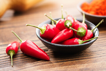 Bowl of red chili pepper pods and red hot pepper ground to powder on background.