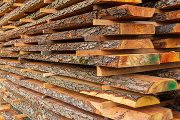 Wooden timber at a sawmill. Boards with bark