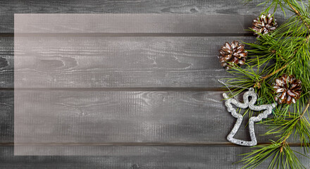 Wooden Christmas background with natural pine needles, cones and silver angel. Frame, banner, postcard
