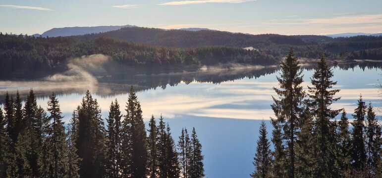 Panoramic shot of the Gronlia hiking place in Bymarka with fir forest trees around the water