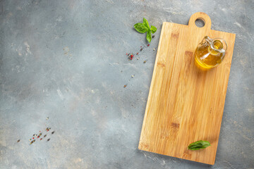 Empty wooden board on concrete table with cooking ingredients on a light background top view. place for text