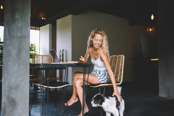 Smiling woman petting dog at home