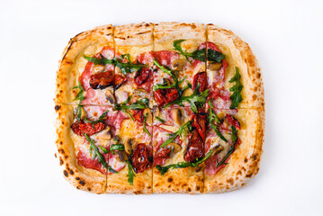 pizza with smoked beef, dried tomatoes, mushrooms and arugula on a white background