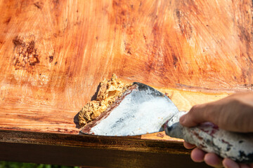 Scraped paint removed with a trowel, renovation of wood surface. Outdoor space