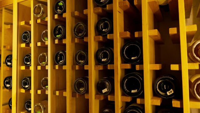 A close-up of a wooden wine shelf with bottles of wine on it in an Italian restaurant the concept of love for win