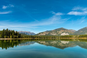 Trees and rocky mountains reflecting on the surface of a tranquil lake