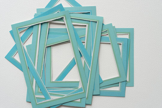 rough pile of blue card paper frames on blank paper