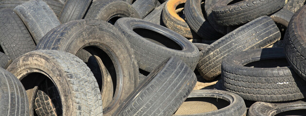 Dirty car tires at a city dump. Industrial pollution of the environment. Dump of unnecessary rubber...