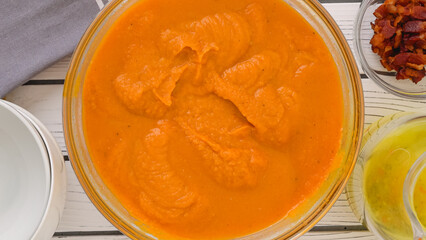 Roasted butternut squash soup recipe, preparation process. Blending roasted vegetables into a puree, adding vegetable stock in a bowl