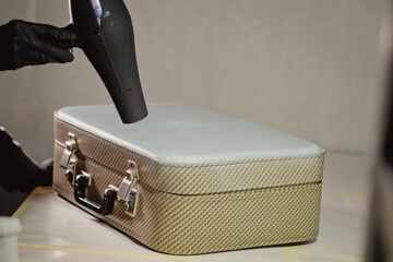 The workplace of the master restorer. Repair of leather goods. Blow-drying of the repair part on a...