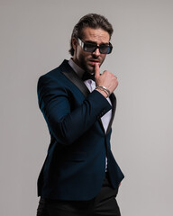 Fototapeta premium seductive elegant man with sunglasses sensually touching lips