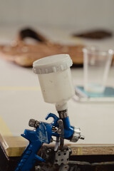 Tools and materials for repair and restoration leather on the table with bag in background. Focus on air gun