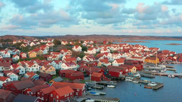 Evening view over fishing village in Sweden. Red houses long flight over town
