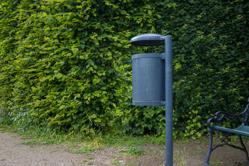 A metal dustbin in the park. Selective focus.