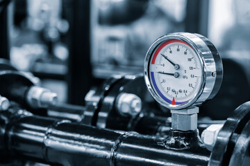 Industrial  concept. equipment of the boiler-house, - valves, tubes, pressure gauges, thermometer. Close up of manometer, pipe, flow meter, water pumps and valves of heating system in a boiler room. - obrazy, fototapety, plakaty