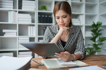 Obraz premium female employee holds a pen and checks investment financial documents.