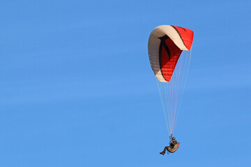 Paraglider flying in a blue sky