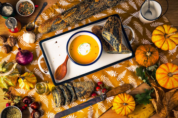 Autumn healthy vegetarian meal pumpkin cream soup with herbs and vegetables, thanksgiving food...
